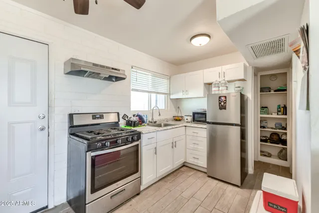 a kitchen with a sink cabinets and stainless steel appliances