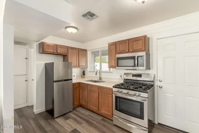 a kitchen with stainless steel appliances a refrigerator stove and microwave