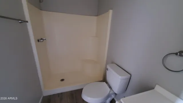 a white toilet sitting next to a shower
