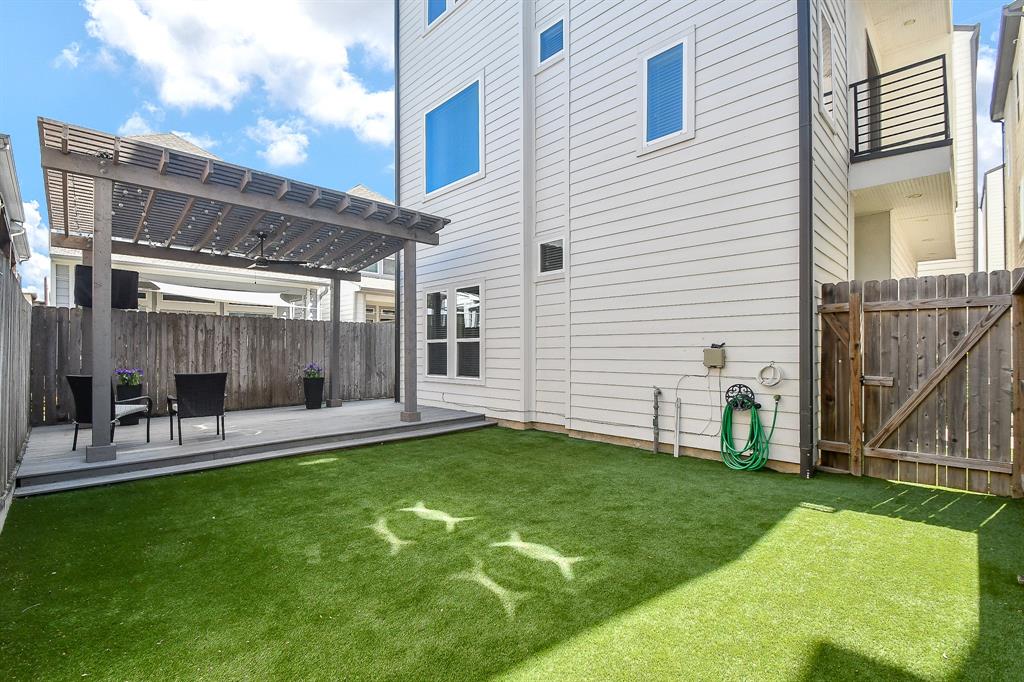 Incredible covered back deck with spacious artificial turf area.