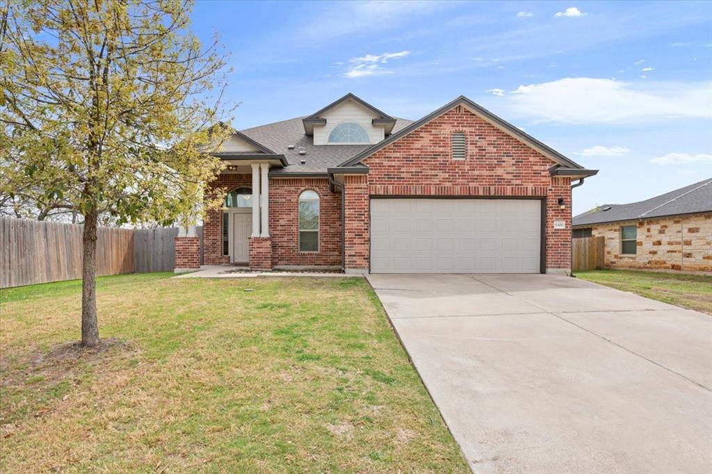 a view of a house with a yard and garage