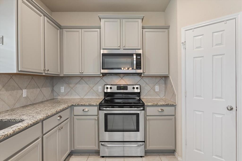5300 Crossville Drive Waco, TX 76708 - Photo 11 of 33 a kitchen with granite countertop white cabinets and stainless steel appliances