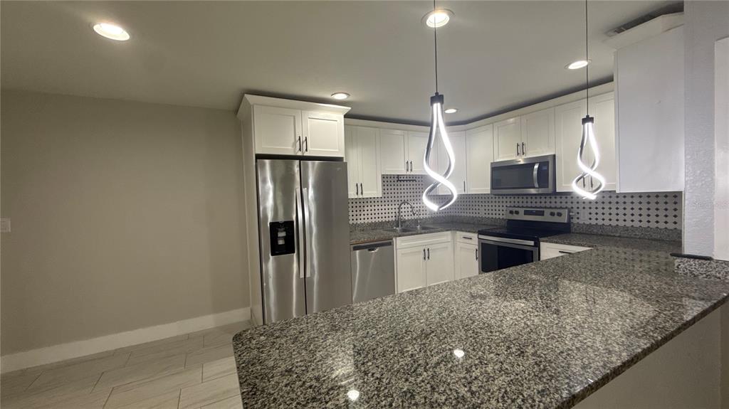 8106 Wichita Way Tampa, FL 33619 - Photo 5 of 21 a kitchen with stainless steel appliances granite countertop a refrigerator and a sink