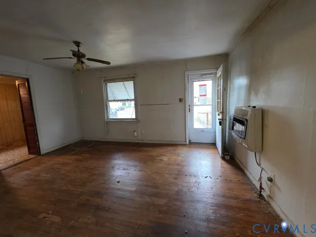 an empty room with windows and a fireplace