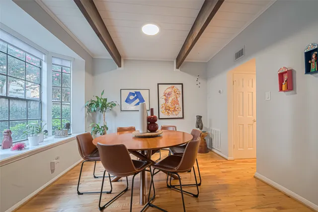 a dining room with furniture a chandelier and wooden floor