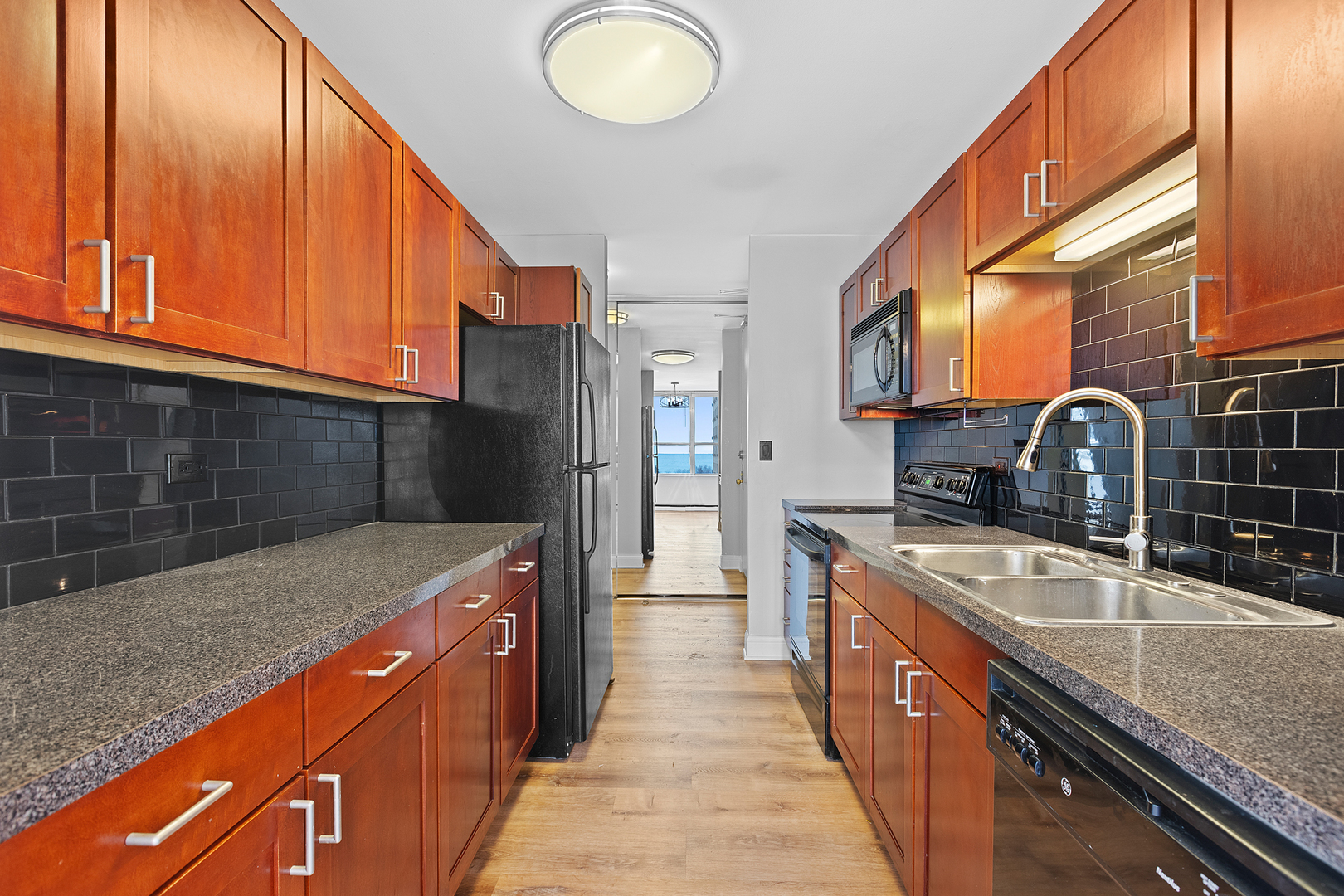 655 West Irving Park Road, Unit 701 Chicago, IL 60613 - Photo 21 of 39 a kitchen with stainless steel appliances granite countertop a sink and a refrigerator