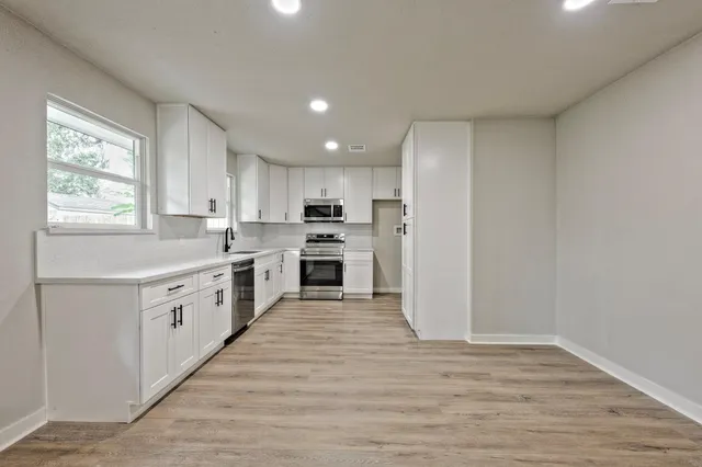 a kitchen with white cabinets and white appliances