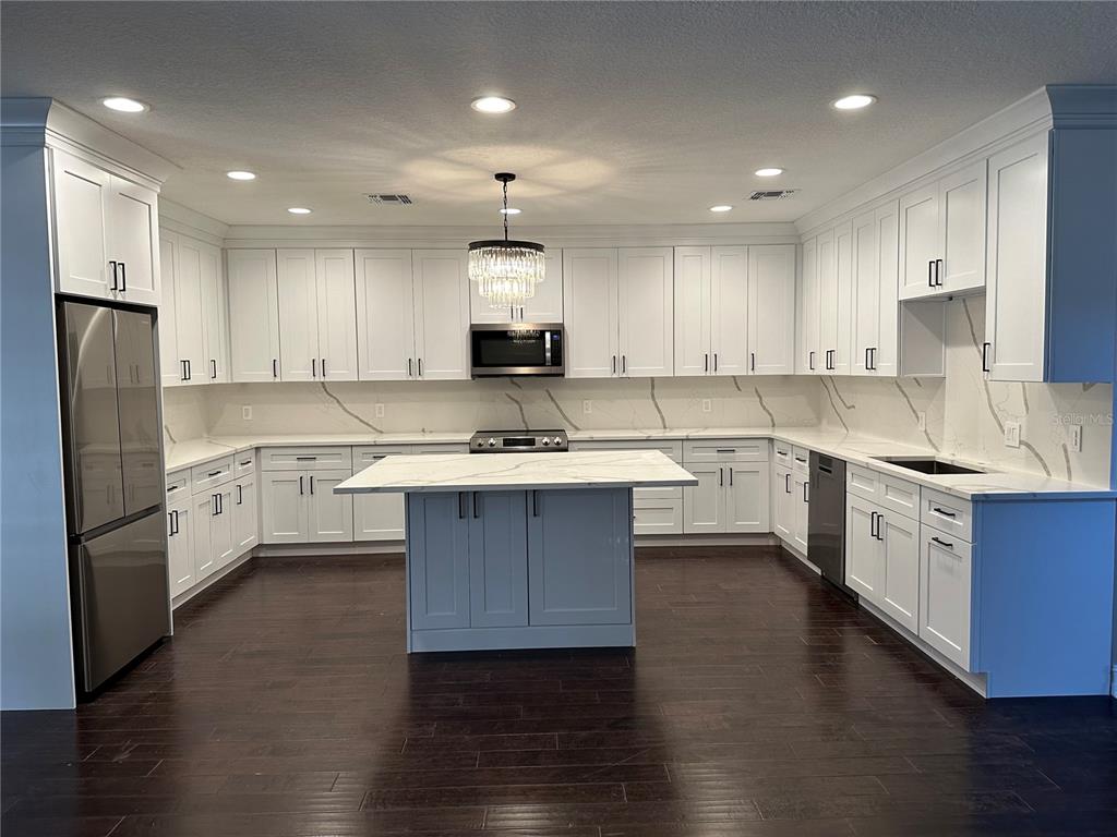 1115 Damask Street Celebration, FL 34747 - Photo 2 of 17 a kitchen with stainless steel appliances sink refrigerator and microwave