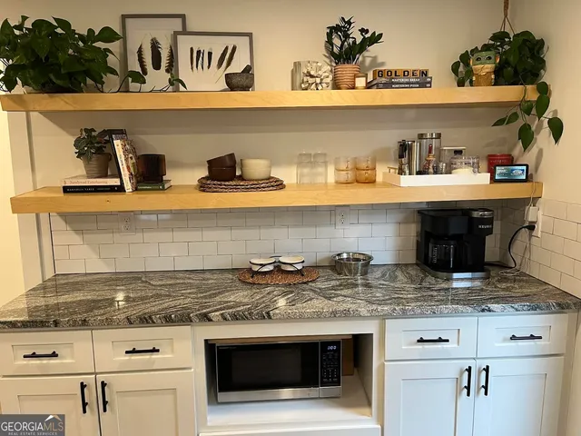 a kitchen with stainless steel appliances kitchen island granite countertop a table chairs and a refrigerator