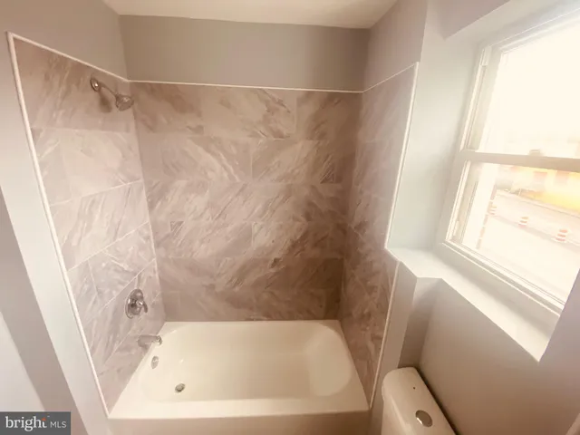 a white toilet sitting next to a window