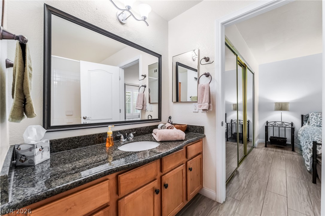 3145 East Flamingo Road, Unit 1092 Las Vegas, NV 89121 - Photo 18 of 33 A well-appointed bathroom vanity features a granite counter and a large, framed mirror.