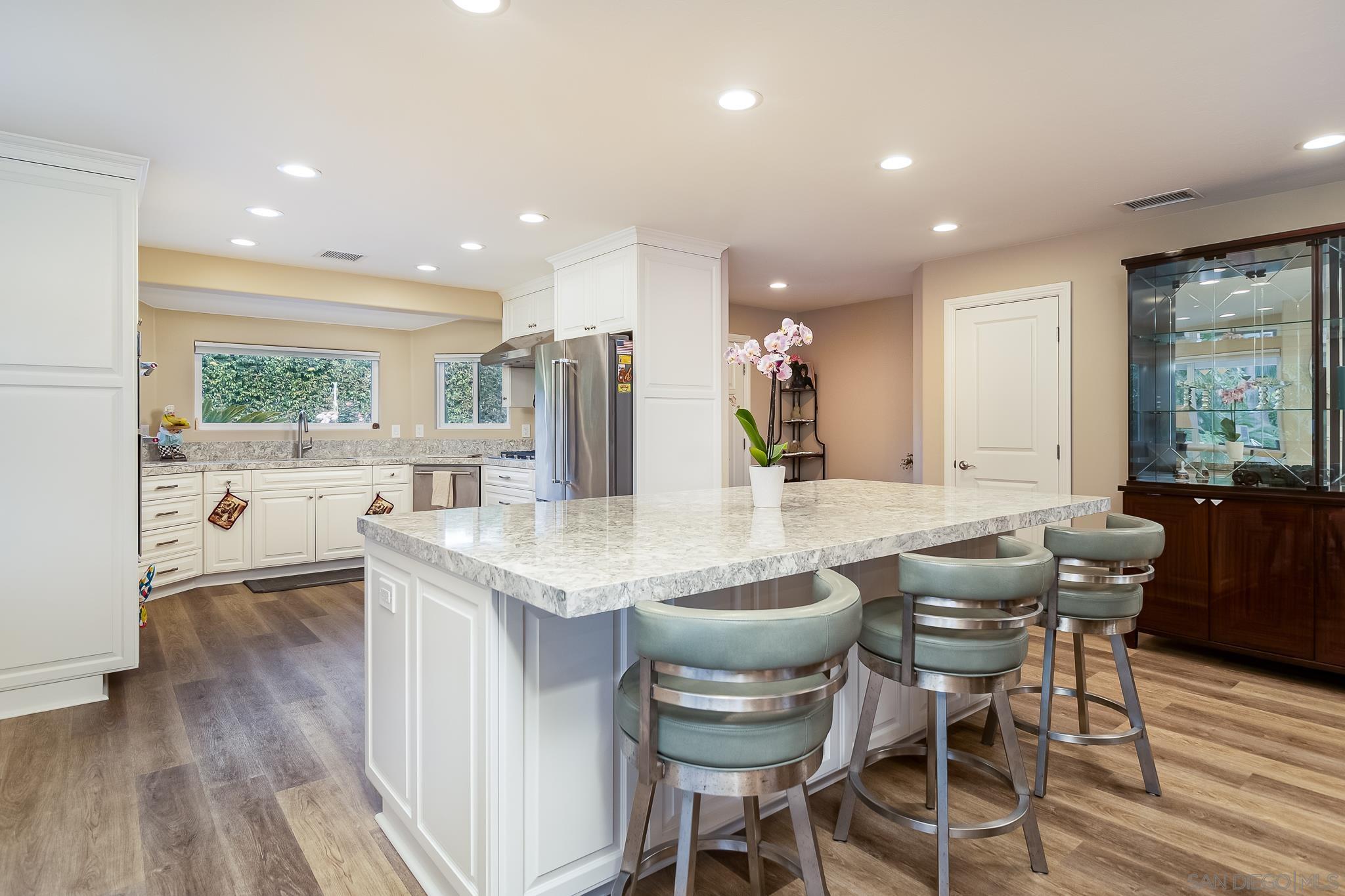 a kitchen with granite countertop kitchen island stainless steel appliances a table and chairs in it
