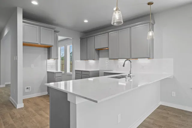 a kitchen with a sink a refrigerator and chairs