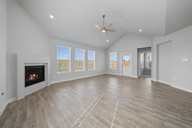 an empty room with windows and fireplace