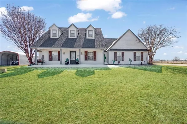 a view of a house with a big yard and large trees