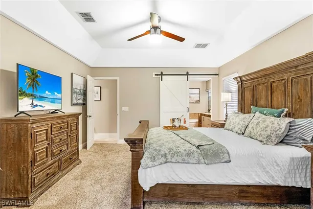 a bedroom with a large bed and a chandelier