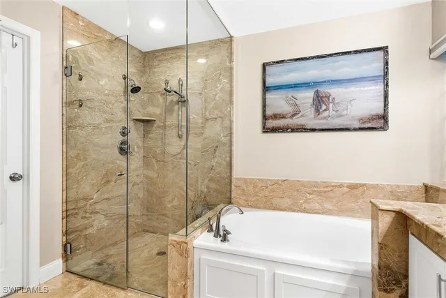 a bathroom with a granite countertop sink a large mirror a shower and a bathtub