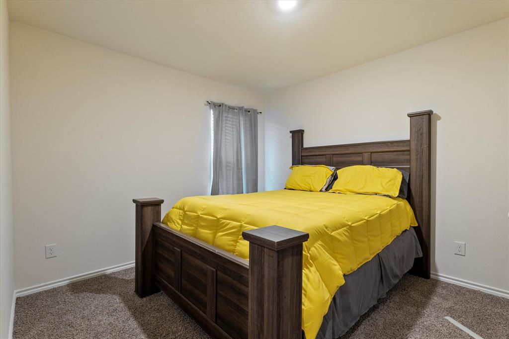 113 Clason Road Royse City, TX 75189 - Photo 16 of 25 a bed sitting in a bedroom next to a window