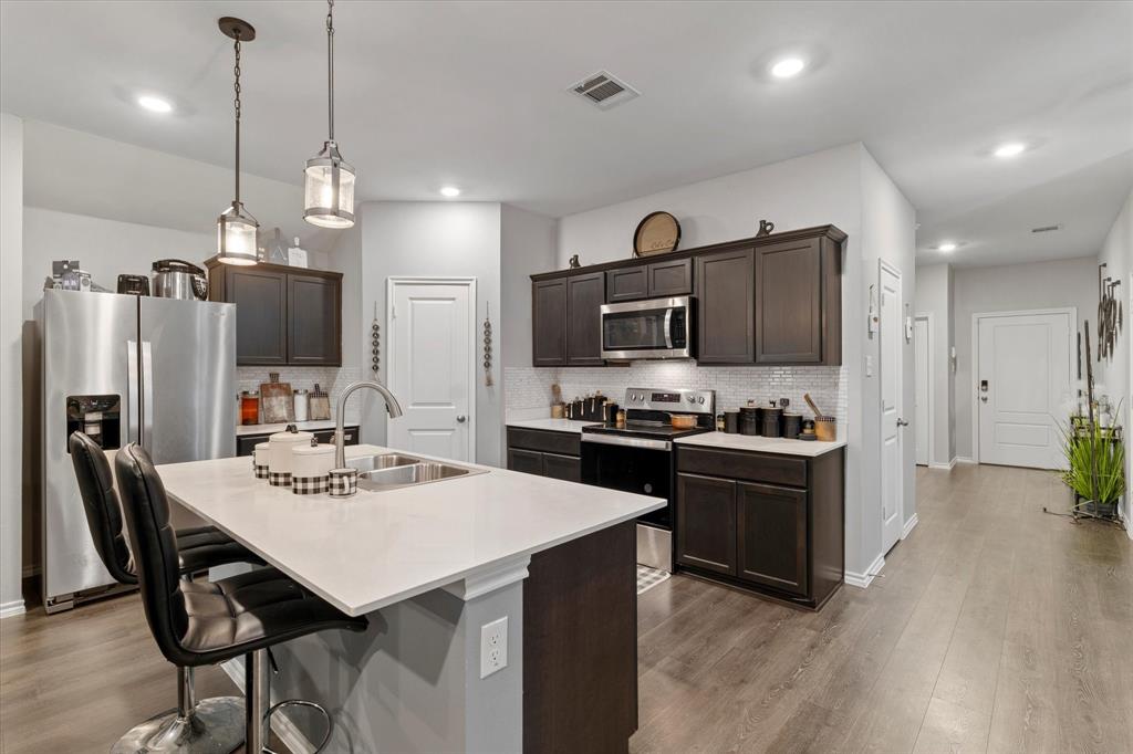 113 Clason Road Royse City, TX 75189 - Photo 10 of 25 a kitchen with stainless steel appliances kitchen island granite countertop a kitchen island a stove a table and chairs