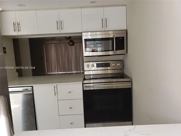 a kitchen with granite countertop a stove microwave and sink
