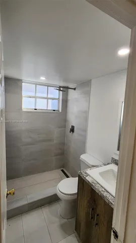 a bathroom with a granite countertop toilet a sink and shower
