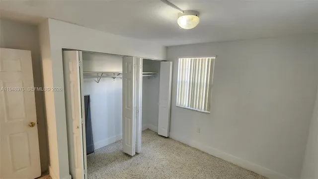 an empty room with windows and closet
