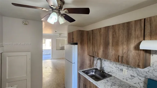 a kitchen with stainless steel appliances granite countertop a sink a stove and a refrigerator