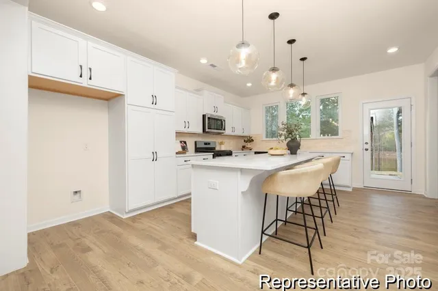 a kitchen with kitchen island granite countertop a sink cabinets and wooden floor