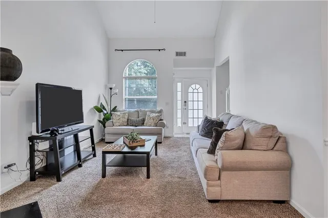 a living room with furniture a window and a flat screen tv
