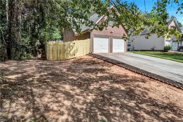a view of a house with a yard and large tree