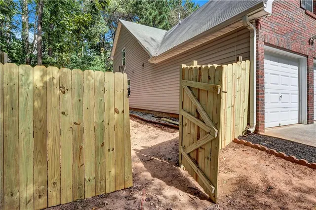 a view of a house with backyard and wooden fence
