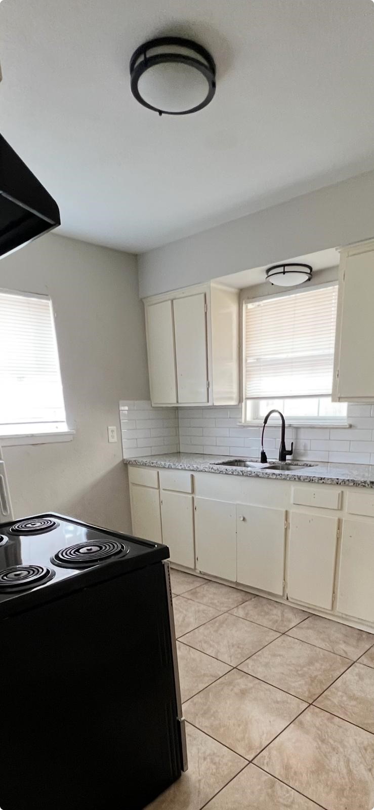 5022 Mallow Street, Unit 7 Houston, TX 77033 - Photo 13 of 20 a kitchen with a sink and a stove