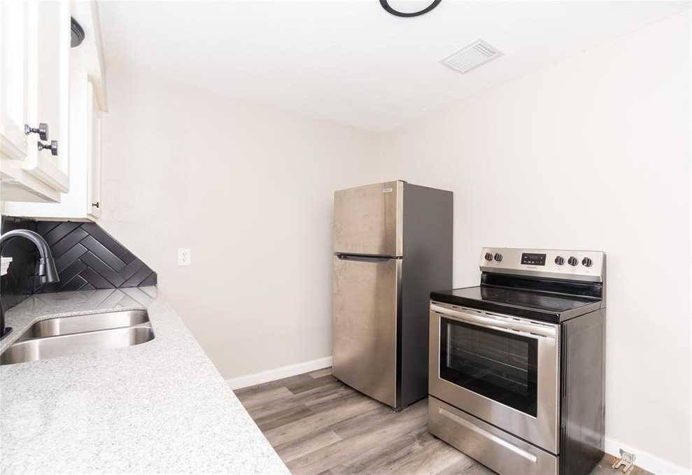 5022 Mallow Street, Unit 7 Houston, TX 77033 - Photo 3 of 20 a kitchen with a refrigerator and a sink