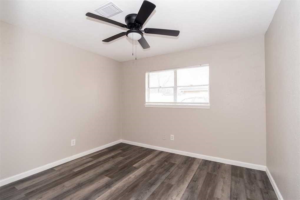 5022 Mallow Street, Unit 7 Houston, TX 77033 - Photo 4 of 20 an empty room with a window and a fan