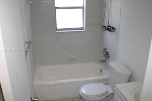 a white bath tub sitting next to a white toilet and sink
