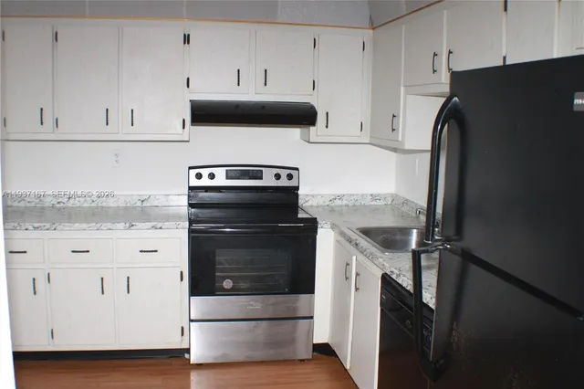 a kitchen with white cabinets and white appliances