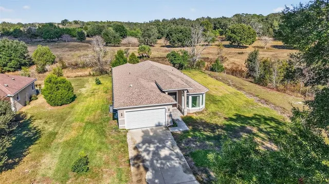 a aerial view of a house with a yard and lake view