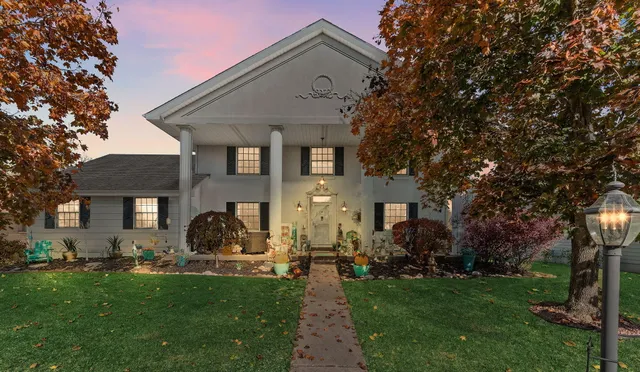 a front view of a house with a garden and plants