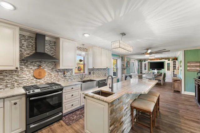 a large kitchen with stainless steel appliances kitchen island a large counter top and a refrigerator