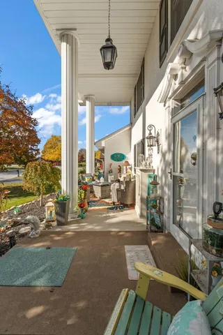 a view of a patio with table and chairs and floor to ceiling window and tree