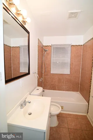 a bathroom with a tub a sink and a mirror