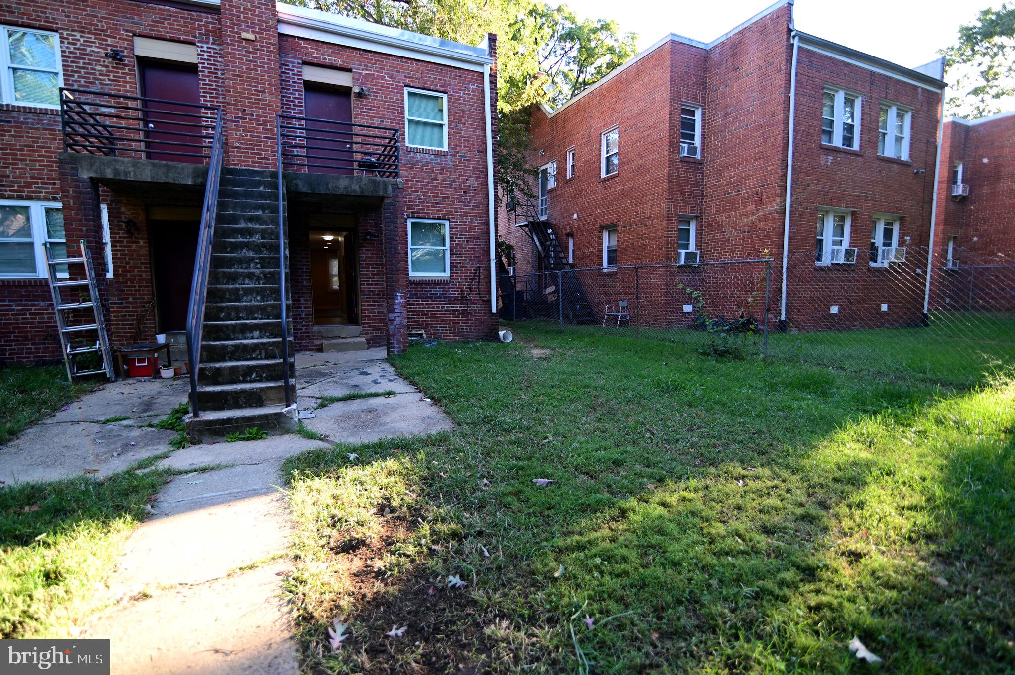 431 Mellon Street Southeast, Unit 2 Washington, DC 20032 - Photo 21 of 24 a view of a brick house with many windows next to a yard