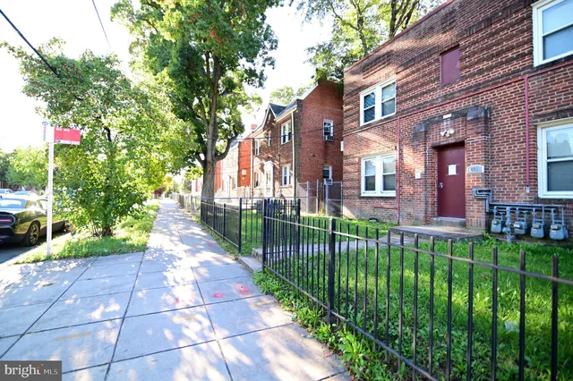 a view of a brick house with a yard and plants
