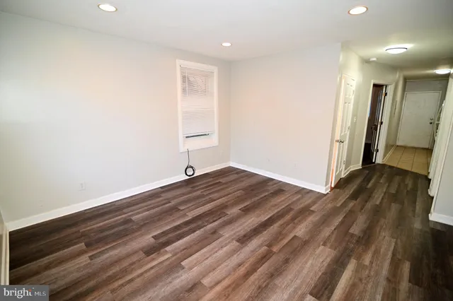 a view of a room with wooden floor and bench