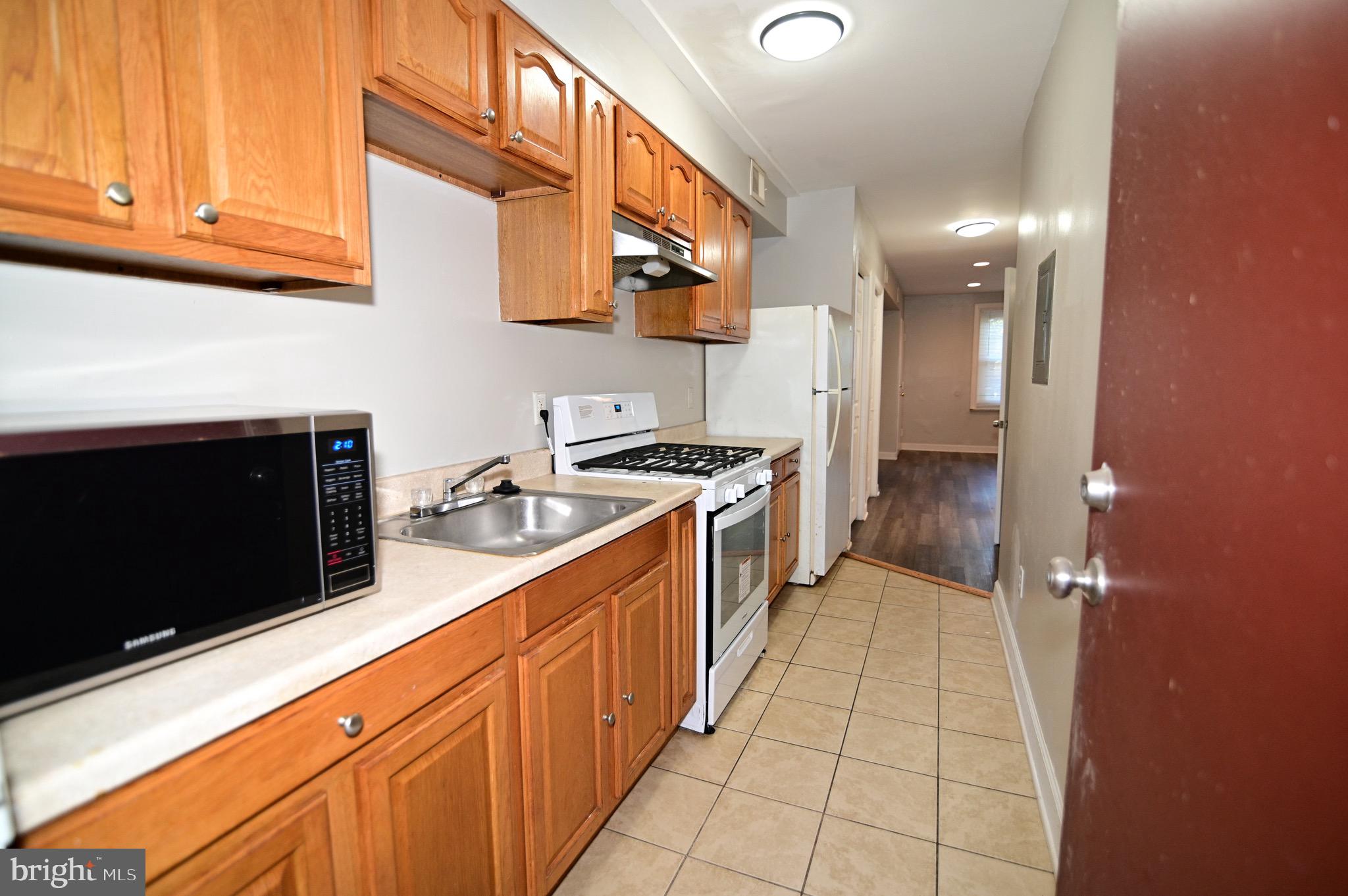 431 Mellon Street Southeast, Unit 2 Washington, DC 20032 - Photo 9 of 24 a kitchen with stainless steel appliances granite countertop a stove a sink and a microwave