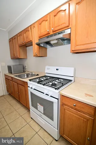 a stove top oven sitting inside of a kitchen