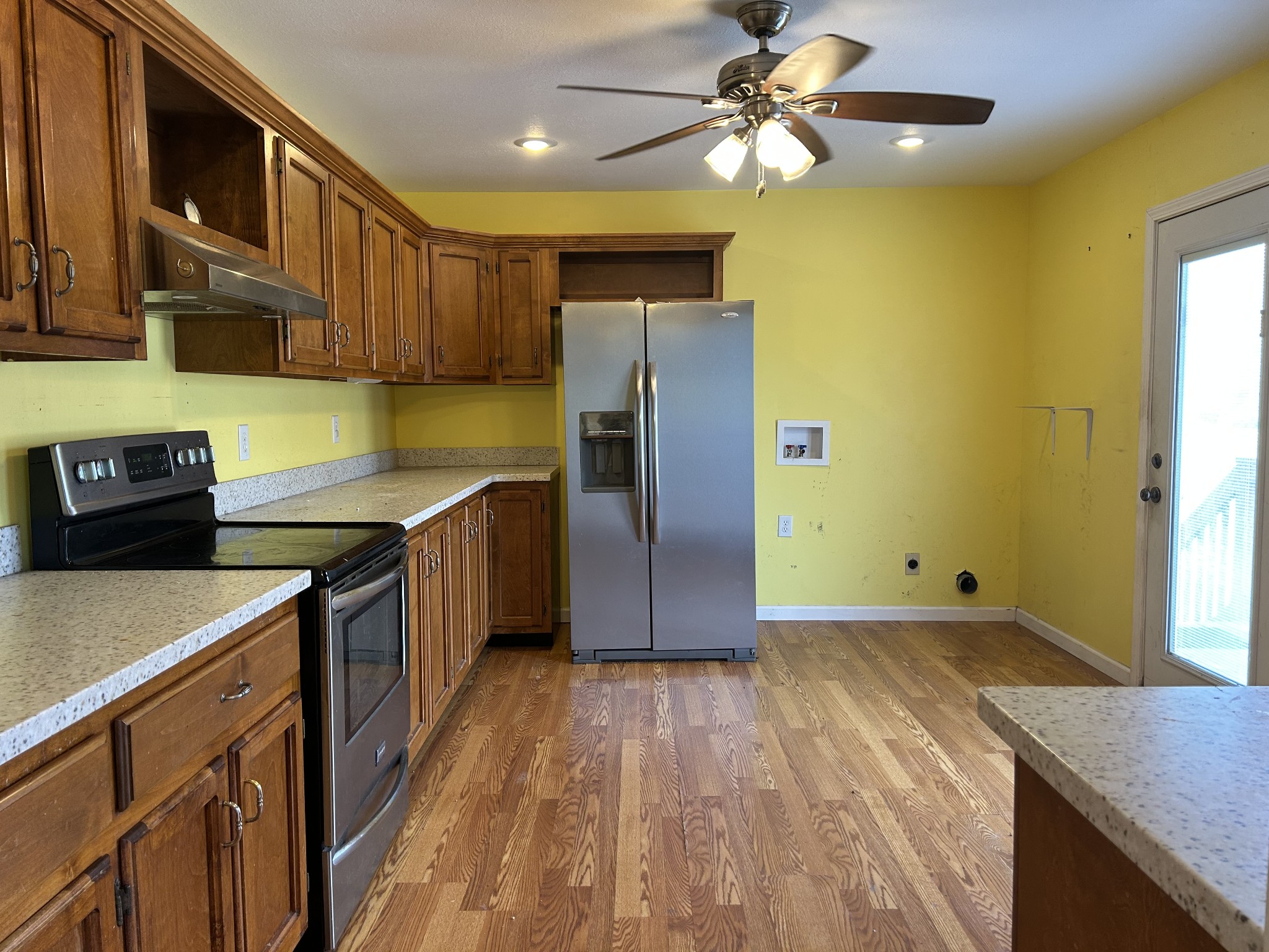 2319 7 Mile Ferry Road Clarksville, TN 37040 - Photo 5 of 15 a kitchen with stainless steel appliances granite countertop a refrigerator a sink dishwasher a stove and a dining table with wooden floor