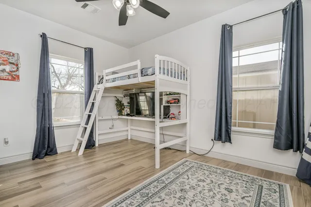 a view of front door with hallway and wooden floor
