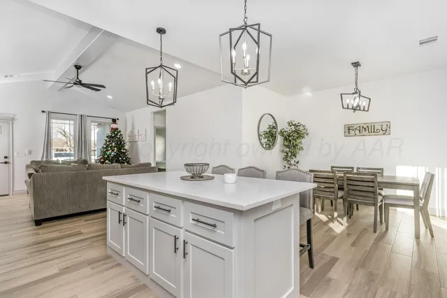 a kitchen with a table chairs and wooden floor