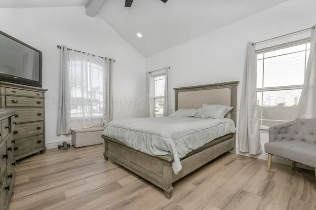 a bedroom with a bed a couch and large window